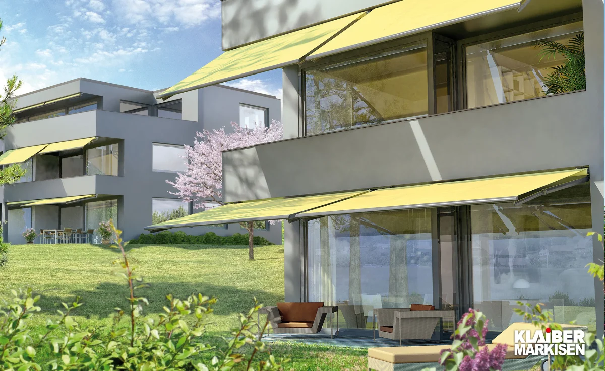 Gelenkarmmarkise in Gelb von Klaiber Markisen an antrhatzifarbenen Haus.